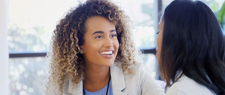 A female health coach counsels a young woman