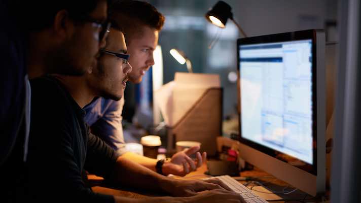 Men looking at data on a computer screen