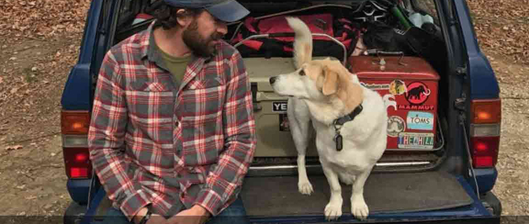Craig and his dog, Fred, sitting on the tailgate of a truck