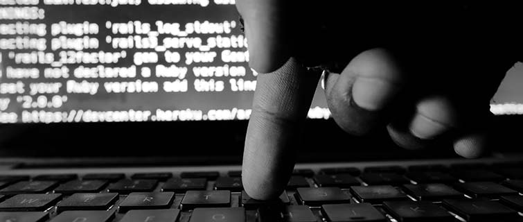 A finger of a Cyber Security expert hitting a keyboard