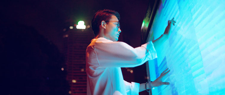 Man studying charts on a large display.